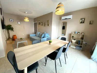 a living room with a table and chairs and a couch at 2 Beachside Apts, 5min Walk to Shore with Internet in Larnaka