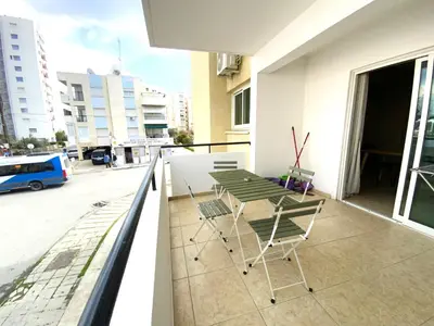 a balcony with two chairs and a table on a building at 2 Beachside Apts, 5min Walk to Shore with Internet in Larnaka