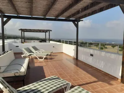 a balcony with chairs and tables on a roof at Crystal Bay Marina B3-5 in Troulli