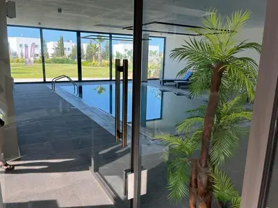 a swimming pool with a palm tree in a building at Crystal Bay Marina B3-5 in Troulli