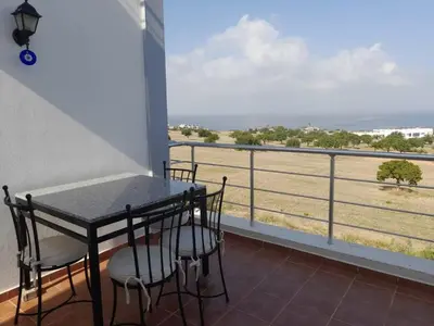 a balcony with a table and chairs and a view of the ocean at Crystal Bay Marina B3-5 in Troulli