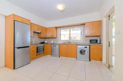 a kitchen with wooden cabinets and a stainless steel refrigerator at Anthorina Greco Villa #10 in Protaras