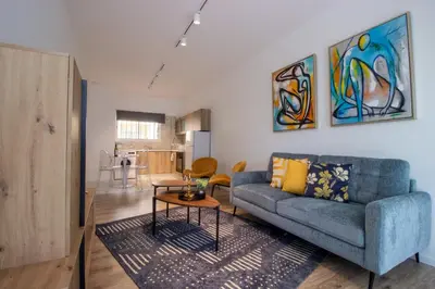 a living room with a blue couch and a table at Modern 2BR Steps from Beach in Voroklini