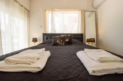 a bedroom with a large bed with towels on it at Modern 2BR Steps from Beach in Voroklini
