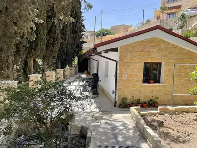 a small brick house with a white door at Monolithos Cottage in Pachna