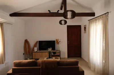 a living room with a couch and a tv at Monolithos Cottage in Pachna