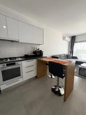 a kitchen with white cabinets and a wooden counter top at Caesar Resort & SPA & Apartments Spacious Studio in Avgorou