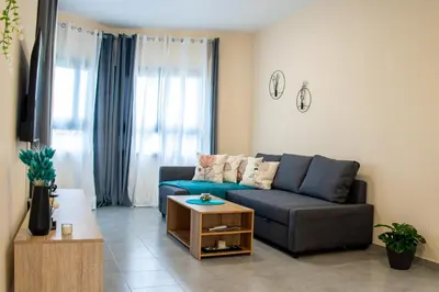 a living room with a blue couch and a table at Sunday's Apartment in Paralimni
