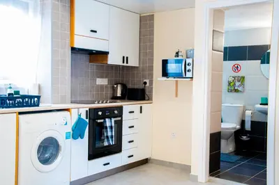 a small kitchen with a washer and dryer at Sunday's Apartment in Paralimni