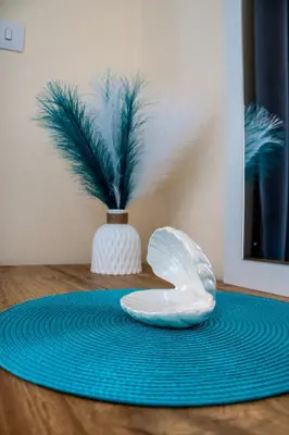a plate on a table with a vase with a plant at Sunday's Apartment in Paralimni