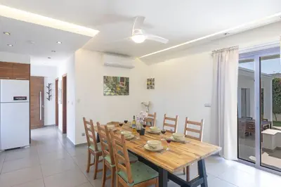 a kitchen and dining room with a wooden table and chairs at Ayia Napa Satin Villa SVI1 in Ayia Napa