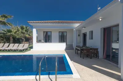 a villa with a swimming pool next to a house at Ayia Napa Satin Villa SVI1 in Ayia Napa
