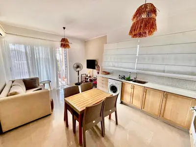 a living room with a table and a couch at Boho Beach Apartment in Tatlisu