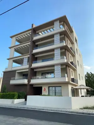 a tall apartment building on the side of a street at Mordern 2BD APT Perfect for Family or Group in Larnaka