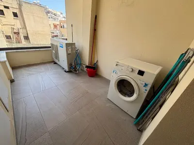 a laundry room with a washing machine and a window at Mordern 2BD APT Perfect for Family or Group in Larnaka