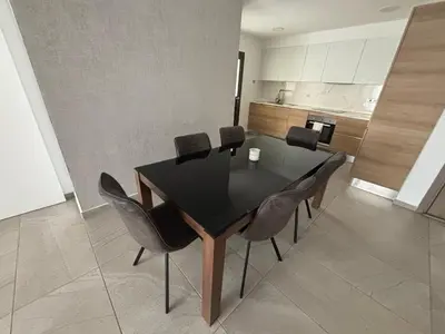 a dining room with a black table and chairs at Mordern 2BD APT Perfect for Family or Group in Larnaka