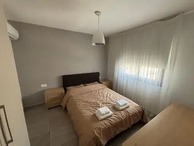 a bedroom with a bed with two towels on it at Mordern 2BD APT Perfect for Family or Group in Larnaka