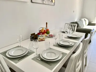 a dining room table with plates and wine glasses at STAY Ease Apartment in Ayia Napa