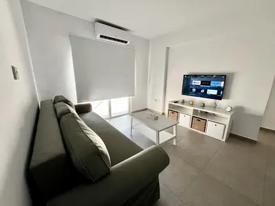 a living room with a couch and a flat screen tv at STAY Ease Apartment in Ayia Napa