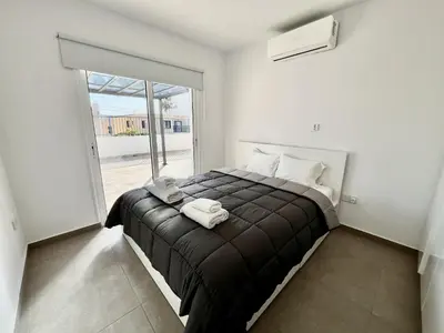 a bedroom with a bed and a large window at STAY Ease Apartment in Ayia Napa