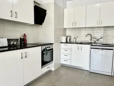 a white kitchen with white cabinets and a sink at STAY Ease Apartment in Ayia Napa