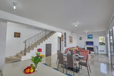 a dining room and living room with a dining table at Pearl Villas in Protaras