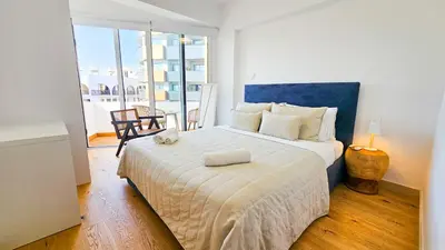 a bedroom with a large bed with a blue headboard at Larnaca Beach Bliss Apartment in Larnaka