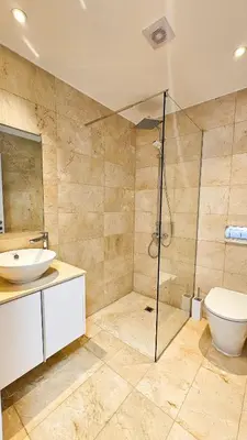 a bathroom with a shower and a toilet and a sink at Larnaca Beach Bliss Apartment in Larnaka
