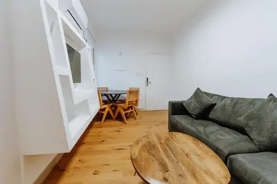 a living room with a couch and a wooden table at Larnaca Beach Bliss Apartment in Larnaka