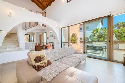 an open living room with a couch and sliding glass doors at Kymma River Villa #4 in Ayia Napa