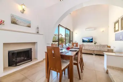 a living room with a table and a fireplace at Kymma River Villa #4 in Ayia Napa