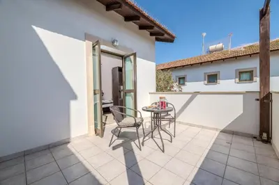 a patio with chairs and a table on a building at Kymma River Villa #4 in Ayia Napa