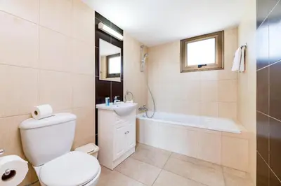 a bathroom with a toilet and a tub and a sink at Kymma River Villa #4 in Ayia Napa