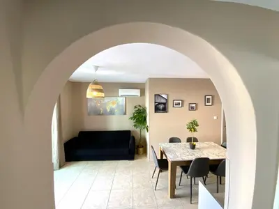 a living room with a table and a couch at 2 Combined Apts, Fast Wi-Fi, 5 Min Walk to Beach in Larnaka
