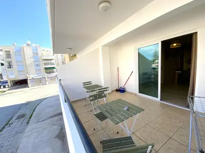 a balcony with chairs and tables on a building at 2 Combined Apts, Fast Wi-Fi, 5 Min Walk to Beach in Larnaka