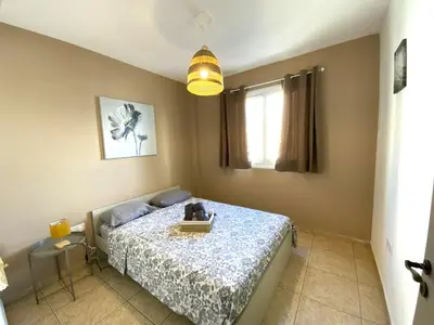 a bedroom with a bed and a table and a window at 2 Cozy Apts, Fast Internet, 5 Min Walk to Beach! in Larnaka