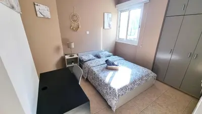 a small bedroom with a bed and a table at 2 Cozy Apts, Fast Internet, 5 Min Walk to Beach! in Larnaka