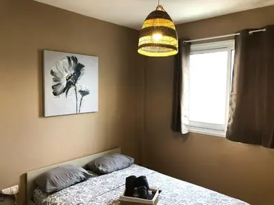 a bedroom with a bed with a flower picture on the wall at Spacious 3Apt Combo, Fast WiFi, 5Min Walk to Beach in Larnaka