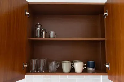 a cupboard filled with lots of cups and mugs at Cozy Apartment with Sea View in Larnaka