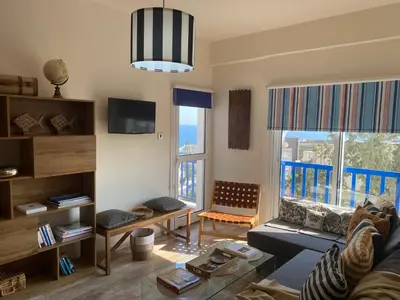 a living room with a couch and a large window at Amathounta Mare Vista Maison in Limassol