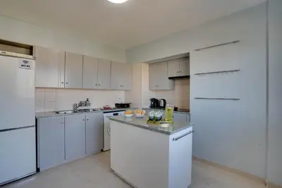 a white kitchen with white appliances and white cabinets at Charming 3-Bed Duplex with Stunning Sea View in Larnaka