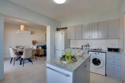 a kitchen with white appliances and a dining room at Charming 3-Bed Duplex with Stunning Sea View in Larnaka