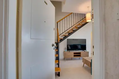 a staircase leading to a living room with a television at Charming 3-Bed Duplex with Stunning Sea View in Larnaka