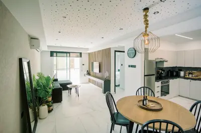 a kitchen and living room with a table and chairs at 2BR Amalfi Blue Apt in Larnaca - Pool & 10Min Walk to Mackenzie Beach! in Larnaka