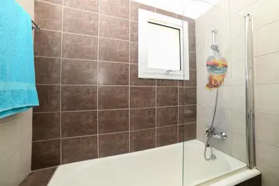 a bathroom with a shower with a tub and a window at Chromata means colorful for a much-needed sunny escape, check your stay! in Protaras