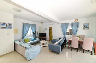 a living room with a couch and a table at Chromata means colorful for a much-needed sunny escape, check your stay! in Protaras