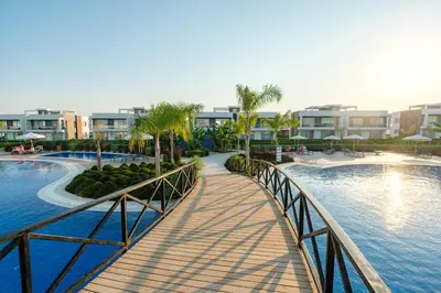 a bridge over a pool at a resort at Spacious & Bright 2BR Apartment, 5min to Beach in Boğaz