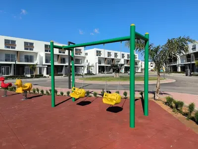 a swing set on a playground in front of a building at Spacious & Bright 2BR Apartment, 5min to Beach in Boğaz