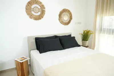 a bedroom with a bed and two mirrors on the wall at 4BR BrandNEW LUX Villa Protaras in Paralimni