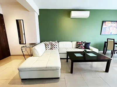 a living room with a couch and a table at Stylish 2BR Apartment with Balcony and Parking near Saint Lazarus and Finikoudes Beach in Larnaka